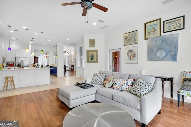 living room with light wood-type flooring and ceiling fan