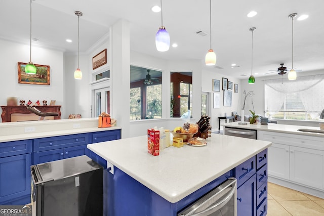 kitchen featuring dishwasher, sink, a center island, decorative light fixtures, and blue cabinets