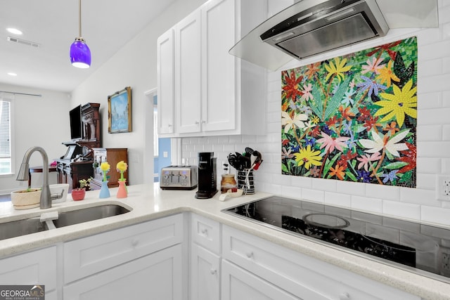 kitchen featuring sink, white cabinets, decorative backsplash, and range hood