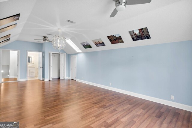 empty room featuring lofted ceiling, a textured ceiling, wood-type flooring, and ceiling fan