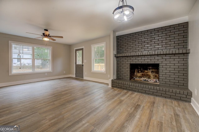 unfurnished living room featuring ceiling fan, a fireplace, and hardwood / wood-style flooring