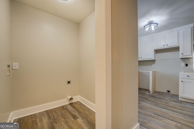 laundry room with light wood-type flooring, hookup for an electric dryer, and cabinets