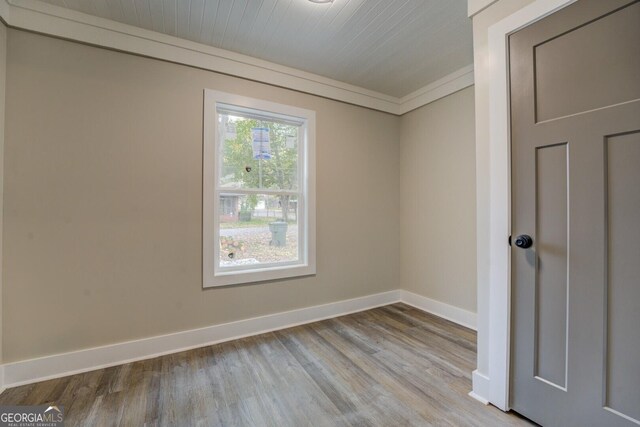 unfurnished room with light hardwood / wood-style flooring and crown molding