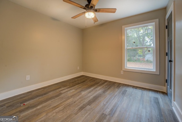 spare room featuring dark wood-type flooring and ceiling fan