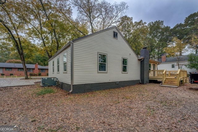 view of side of property with a wooden deck and central air condition unit