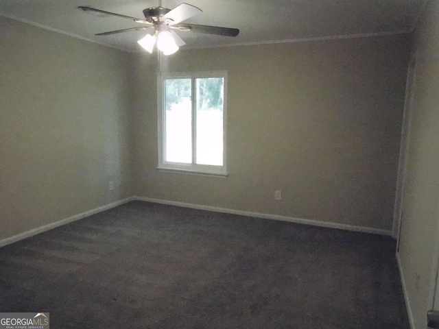 empty room featuring ceiling fan, ornamental molding, and dark colored carpet