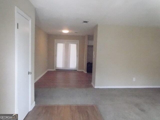 hallway featuring baseboards and wood finished floors
