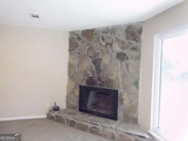 detailed view of carpet flooring and a fireplace