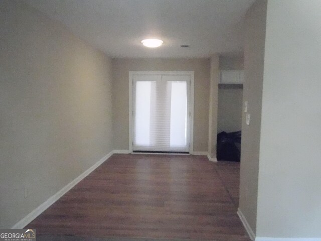 hallway featuring wood finished floors and baseboards