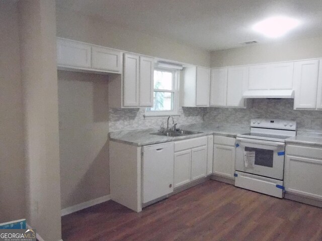 kitchen featuring white appliances, a sink, under cabinet range hood, decorative backsplash, and white cabinetry