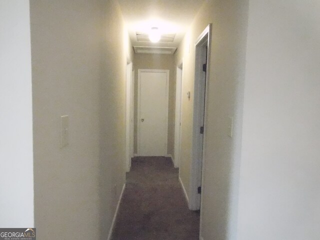 hall with dark colored carpet