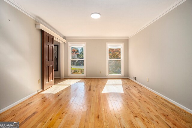 spare room with crown molding and light hardwood / wood-style flooring