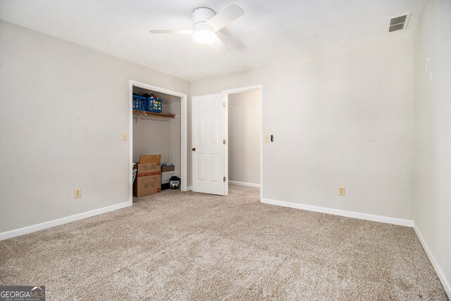 unfurnished bedroom with a closet, carpet, and ceiling fan