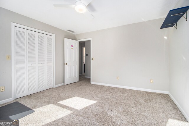 unfurnished bedroom featuring a closet, ceiling fan, and light colored carpet