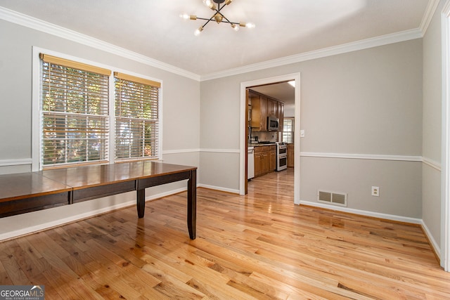 dining space featuring light hardwood / wood-style flooring, ornamental molding, and a notable chandelier