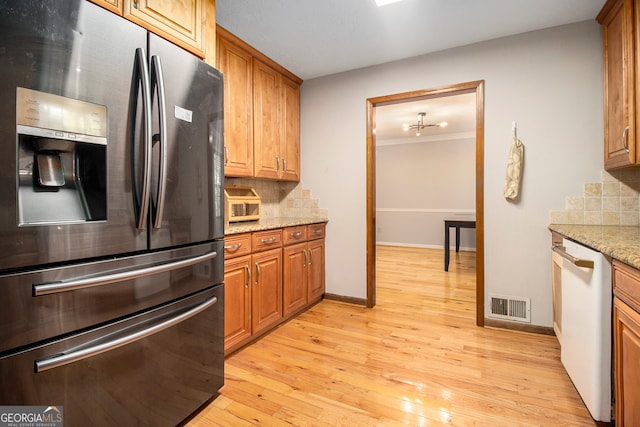 kitchen with light hardwood / wood-style flooring, tasteful backsplash, stainless steel fridge with ice dispenser, and dishwasher