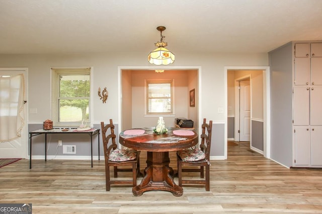 dining space featuring baseboards, visible vents, and light wood-type flooring