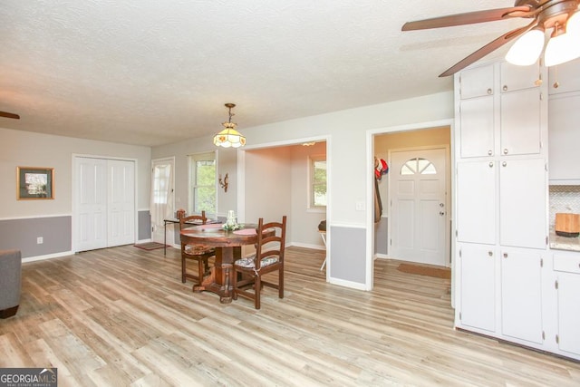 dining room featuring ceiling fan, a textured ceiling, and light wood-style flooring