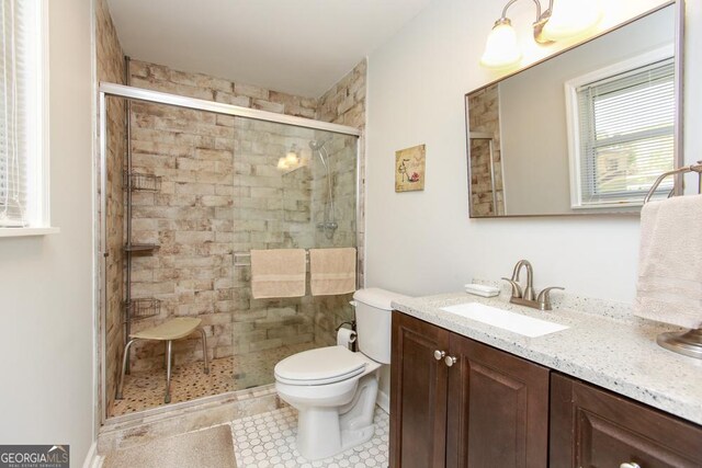 bathroom with toilet, vanity, tile patterned floors, and tile walls