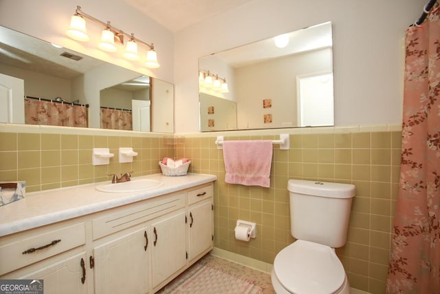 full bathroom with tile patterned floors, visible vents, toilet, tile walls, and vanity