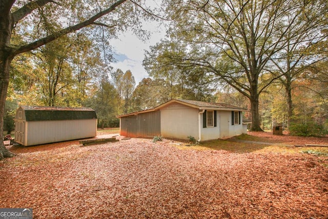 view of side of property with an outdoor structure and a shed