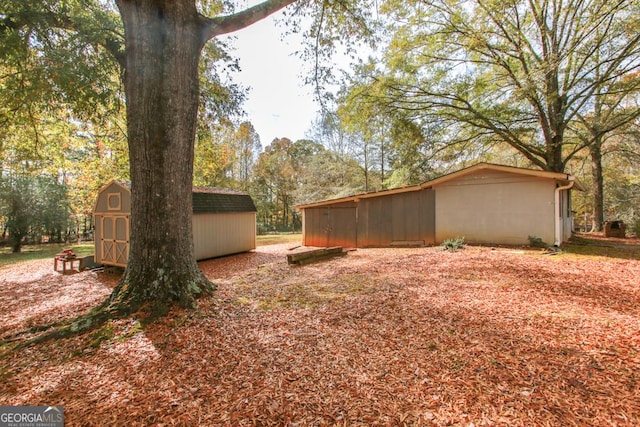 view of yard featuring a storage unit and an outbuilding