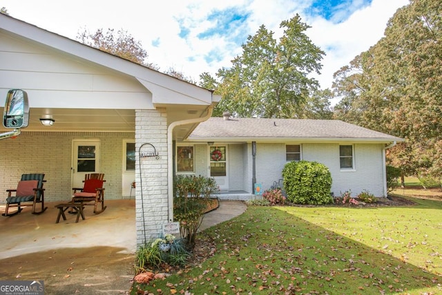 view of front of property featuring brick siding and a front yard