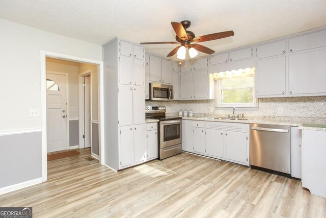 living room with sink, a textured ceiling, light hardwood / wood-style floors, and ceiling fan