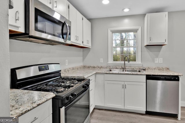 kitchen featuring sink, white cabinets, and appliances with stainless steel finishes