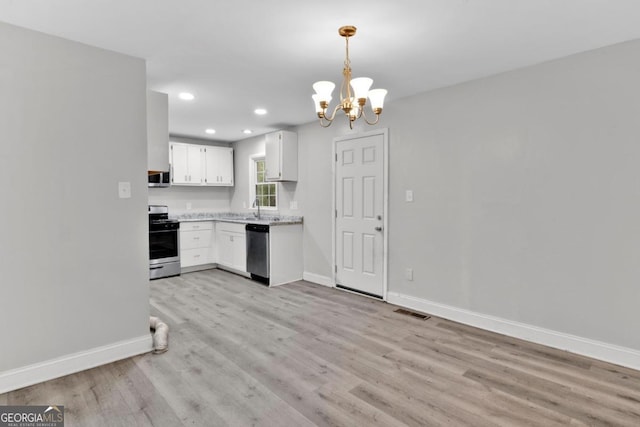 kitchen featuring white cabinetry, an inviting chandelier, light hardwood / wood-style floors, pendant lighting, and appliances with stainless steel finishes