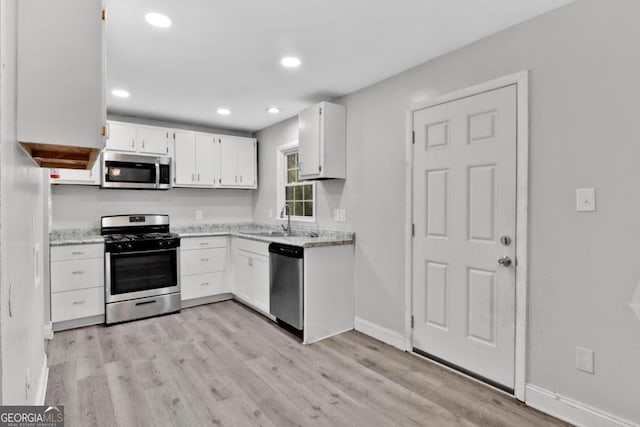 kitchen with light hardwood / wood-style flooring, white cabinetry, sink, and stainless steel appliances