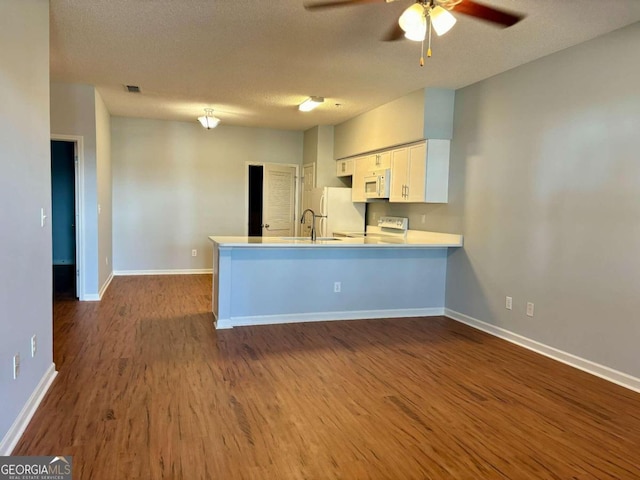 kitchen featuring kitchen peninsula, white cabinets, hardwood / wood-style floors, and white appliances