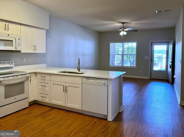 kitchen featuring kitchen peninsula, white cabinets, dark hardwood / wood-style flooring, sink, and white appliances