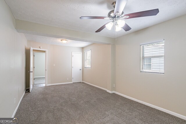 carpeted empty room with a textured ceiling and ceiling fan