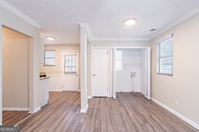 entryway featuring crown molding, a wealth of natural light, and light wood-type flooring