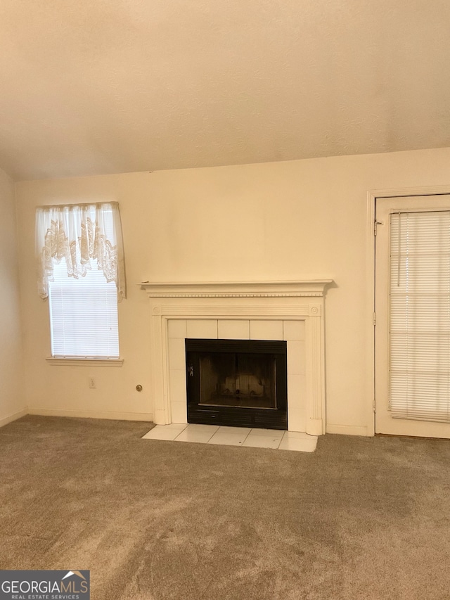 details with a tiled fireplace and carpet