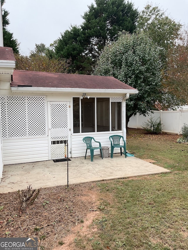 back of house with a sunroom, a patio area, a lawn, and ceiling fan