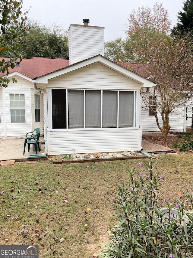 back of house with a patio, a sunroom, and a lawn