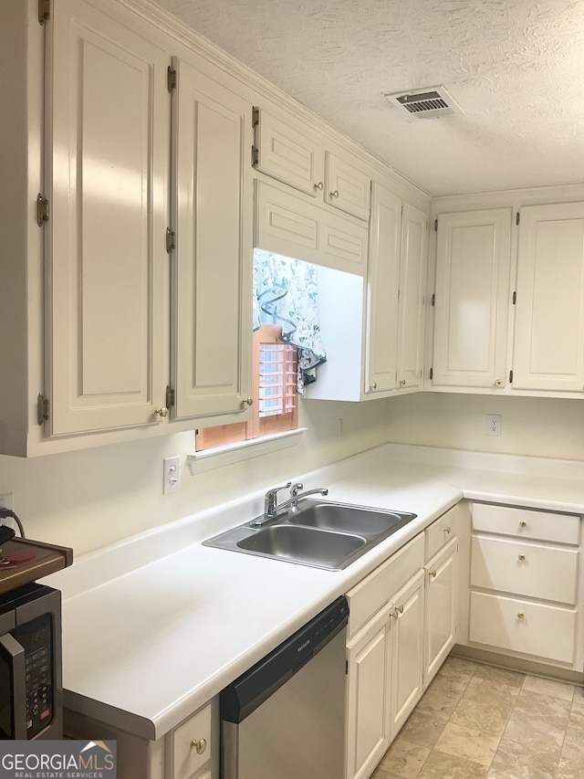 kitchen with dishwasher, white cabinets, sink, and a textured ceiling