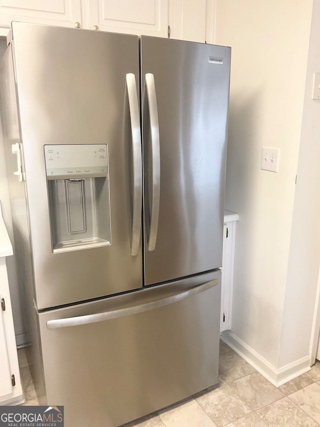 room details with stainless steel fridge and white cabinetry