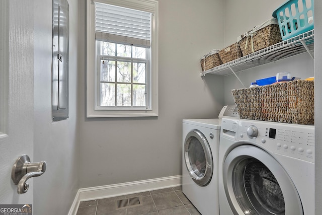 clothes washing area featuring washing machine and clothes dryer and dark tile patterned floors