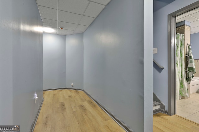 interior space with a paneled ceiling and light hardwood / wood-style floors