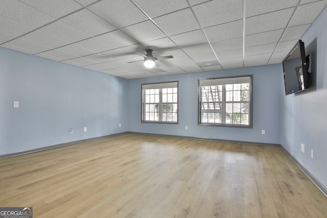 unfurnished room featuring a paneled ceiling, ceiling fan, and light hardwood / wood-style flooring