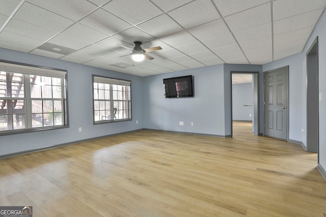 empty room with light hardwood / wood-style flooring, a paneled ceiling, and ceiling fan