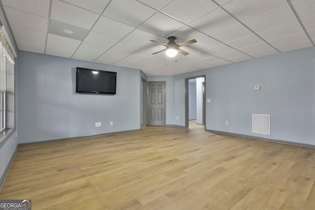 spare room featuring a drop ceiling, light wood-type flooring, and ceiling fan