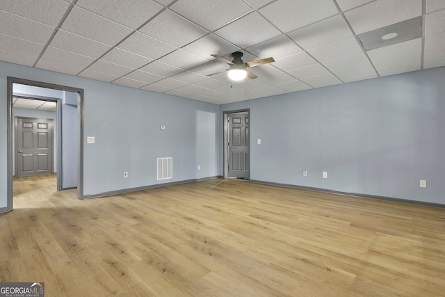 spare room with a drop ceiling, light hardwood / wood-style flooring, and ceiling fan