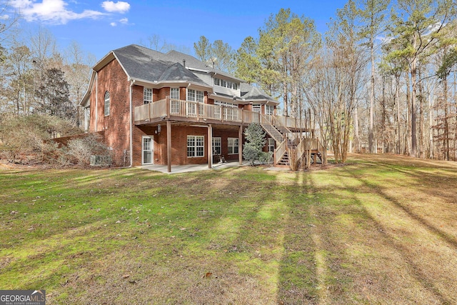 rear view of house featuring a patio area, a lawn, and a wooden deck