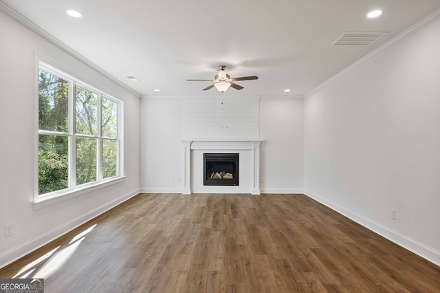 unfurnished living room featuring dark hardwood / wood-style floors, ceiling fan, and crown molding