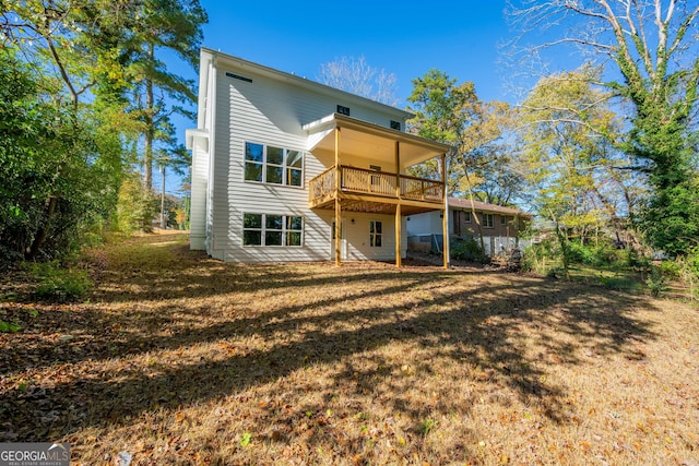 back of house with a deck and a yard