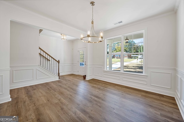 entryway with a notable chandelier, dark hardwood / wood-style flooring, and crown molding